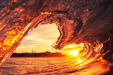 ocean wave with orange sunset